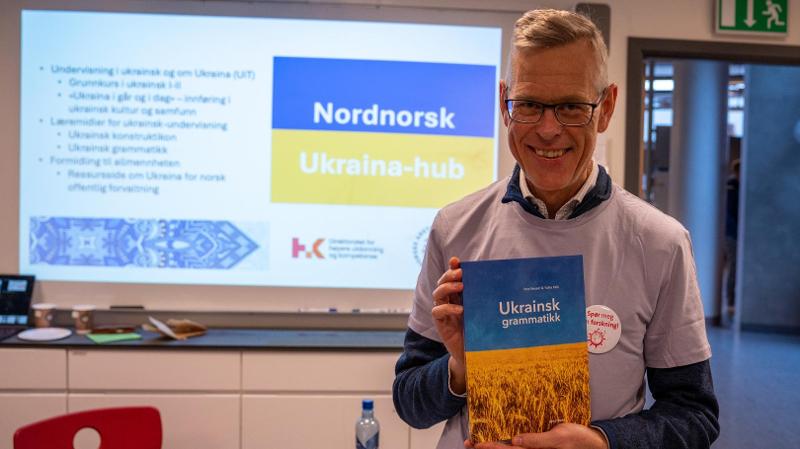 en mann som holder en bok med ukrainsk grammatikk