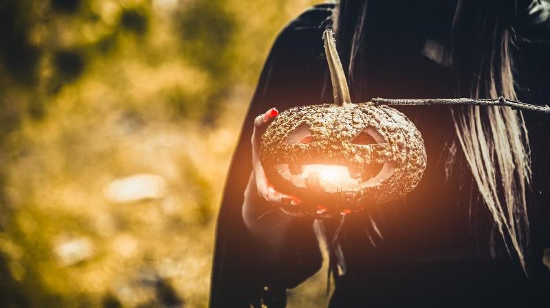 lite halloween gresskar som lyser opp og blir holdt av en person 